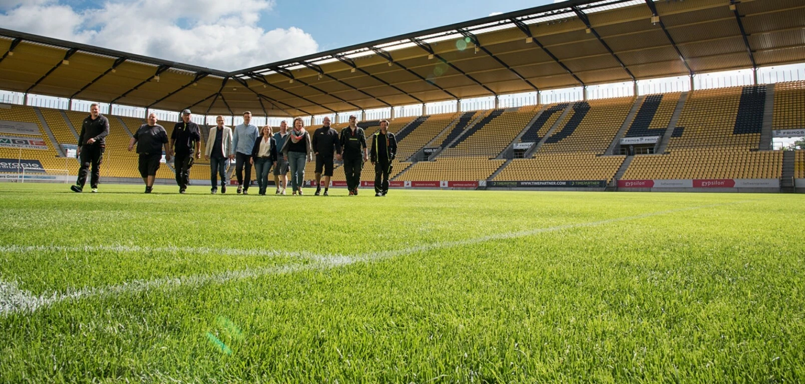 Mehrere Menschen laufen auf dem Rasenplatz